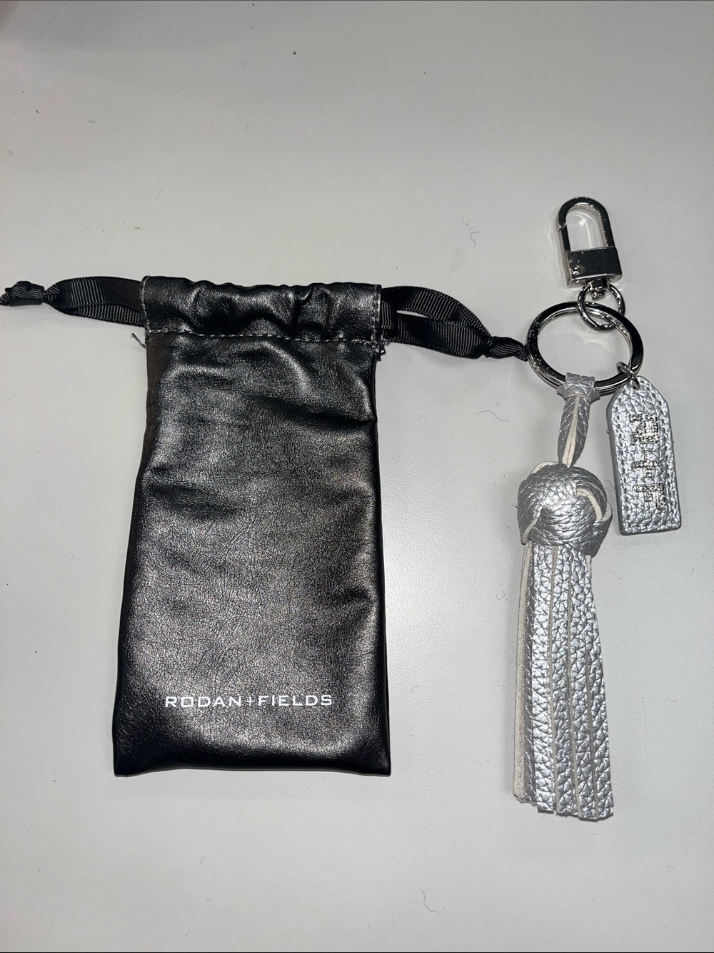 Rodan + Fields Black Pouch with Silver leather Tassel Keyring